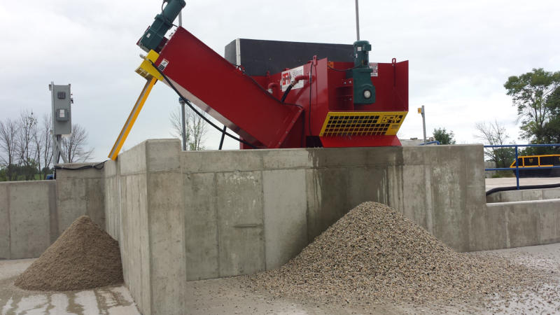 red steel machine with aggregate piles